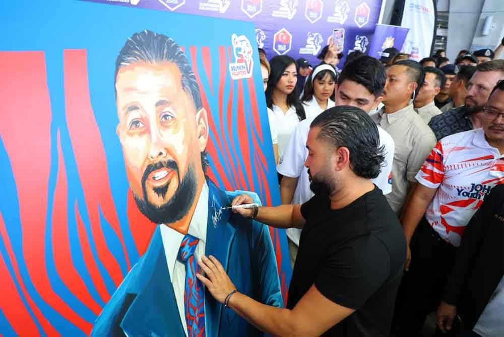 Tunku Mahkota Ismail menurunkan tanda tangan sebelum sesi podcast sempena Program Johor Youth Meet-up bermula di Kompleks Sukan Educity, Iskandar Puteri pada Ahad.