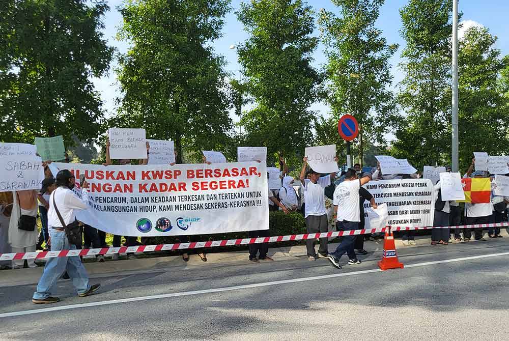 Sekumpulan pencarum dan NGO melakukan demonstrasi secara aman di hadapan bangunan Menara KWSP pada Isnin