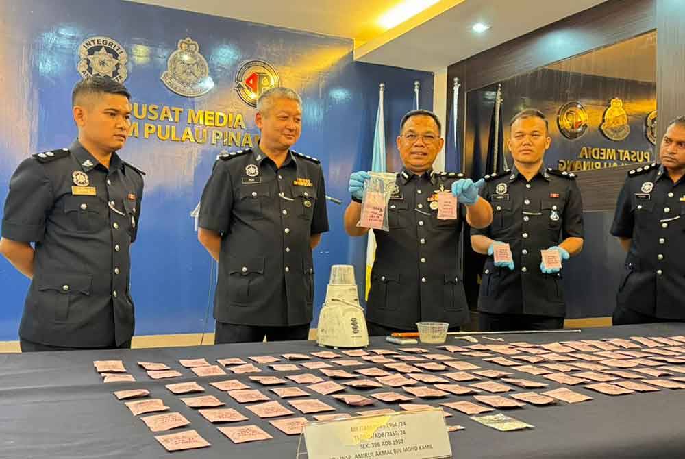 Razlam (tiga dari kiri) menunjukkan peket merah jambu yang mengandungi serbuk MDMA.