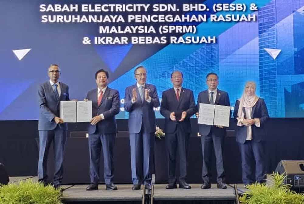 Masidi (tiga dari kiri) menyaksikan pihak SESB dan SPRM menandatangani MoU dan Ikrar Bebas Rasuah di SICC Kota Kinabalu.