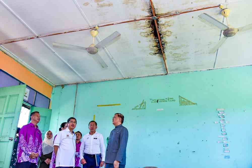 Arifin (dua dari kiri) meninjau keadaan bumbung sekolah yang rosak di bangunan SMK Gadong, Beaufort.