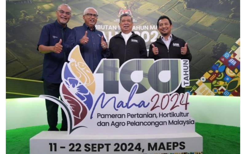 Mohamad (dua dari kanan) bergambar di replika tugu MAHA 2024 yang merupakan penganjuran edisi ke-100 sambil disertai Ketua Setiausaha, Kementerian Pertanian dan Keterjaminan Makanan (KPKM), Datuk Lokman Hakim Ali (kanan). 