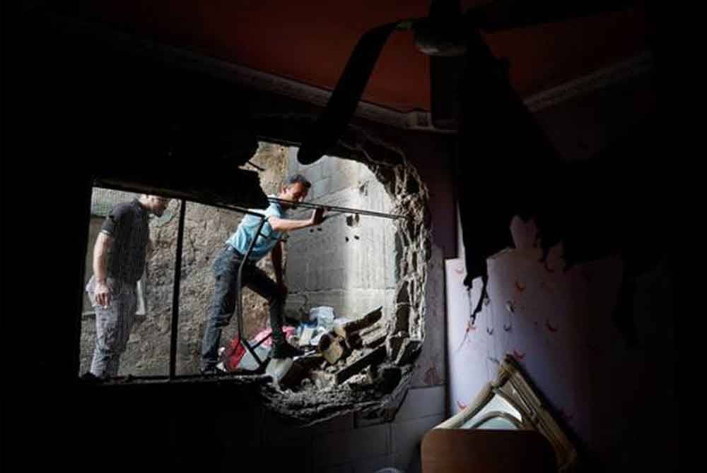 Rakyat Palestin memeriksa sebuah rumah yang musnah akibat serangan tentera rejim Zionis Israel di Tebing Barat. - Foto Reuters
