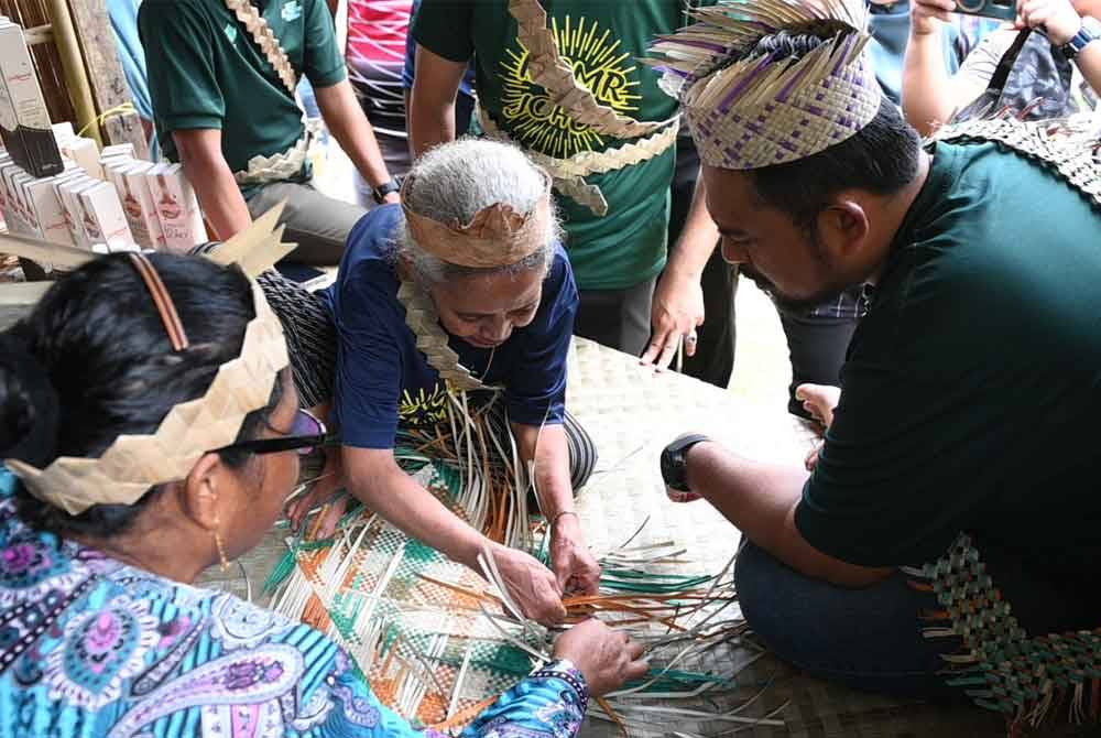 Manndzri (kanan) melihat hasil kraf dan beramah-mesra bersama penduduk Kampung Peta.