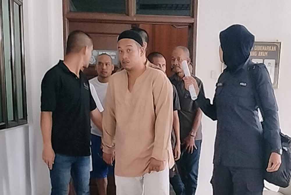 Muhammad Tuah (tengah) ketika dibawa keluar dari Mahkamah Sesyen pada Rabu.