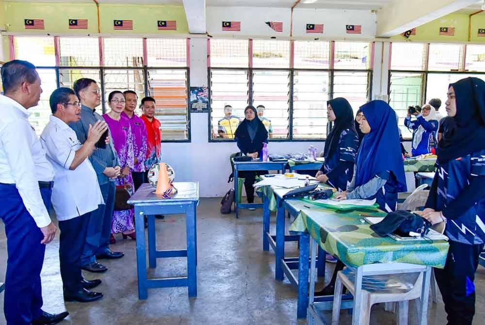 Mohd Arifin (tiga dari kiri) dan Raisin (dua dari kiri) ketika melawat kelas sementara bagi pelajar Tingkatan Enam di SMK Gadong, Beaufort.