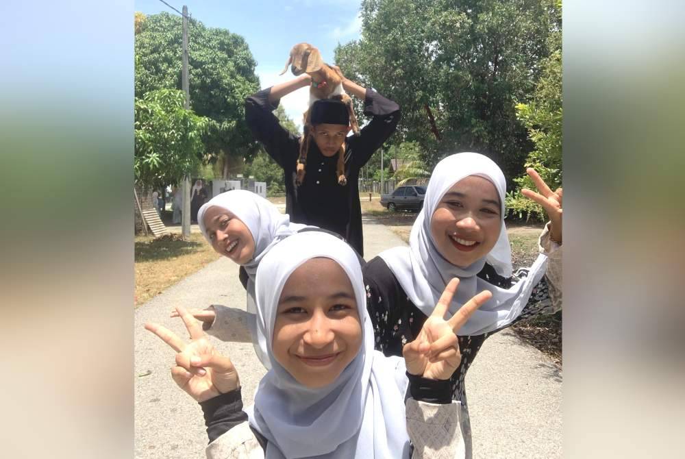 Norin (kiri) bersama adik beradiknya merakam gambar bersama Manja.