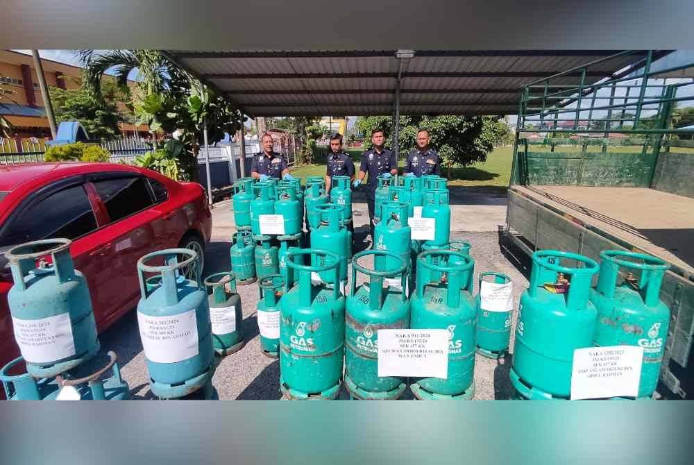 Mulkiaman (kiri) menunjukkan antara barangan yang berjaya dirampas semula iaitu sejumlah tong gas yang dicuri suspek sejak awal tahun lalu.