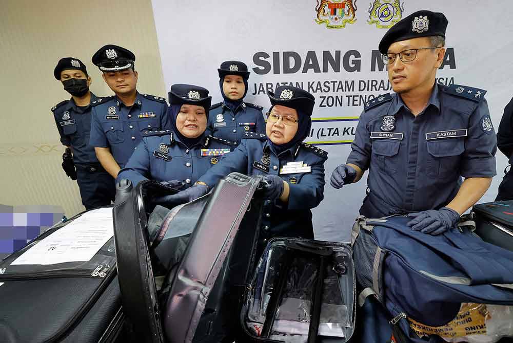 Norlela (dua, kanan) menunjukkan bagasi yang dirampas pada sidang media, Khamis.