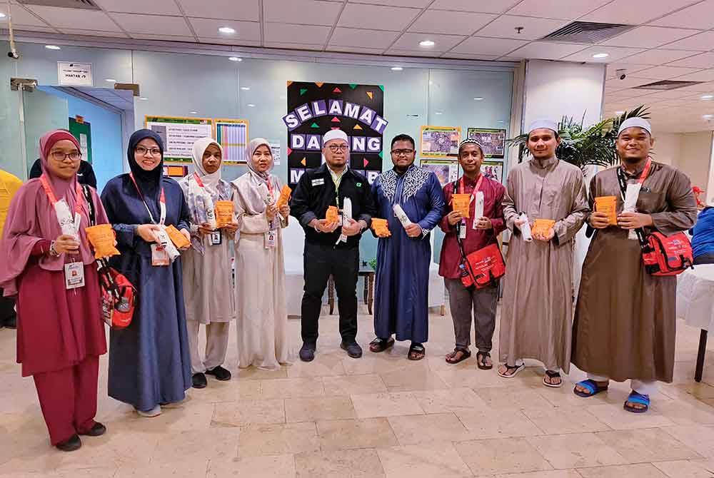 Jemaah haji menunjukkan batu untuk kegunaan melontar jamrah dan payung yang diterima daripada pihak TH untuk kegunaan mereka semasa di Arafah. Foto Bernama