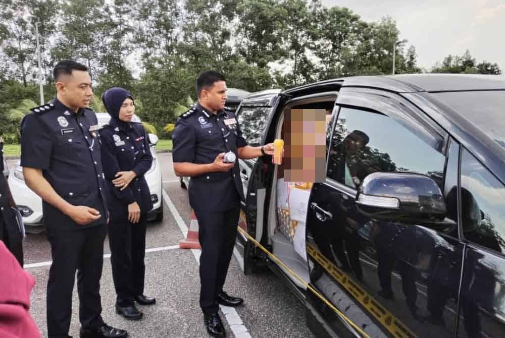 Kumarasan (kanan) meliihat kenderaan yang dipenuhi tin minuman keras berkenaan.