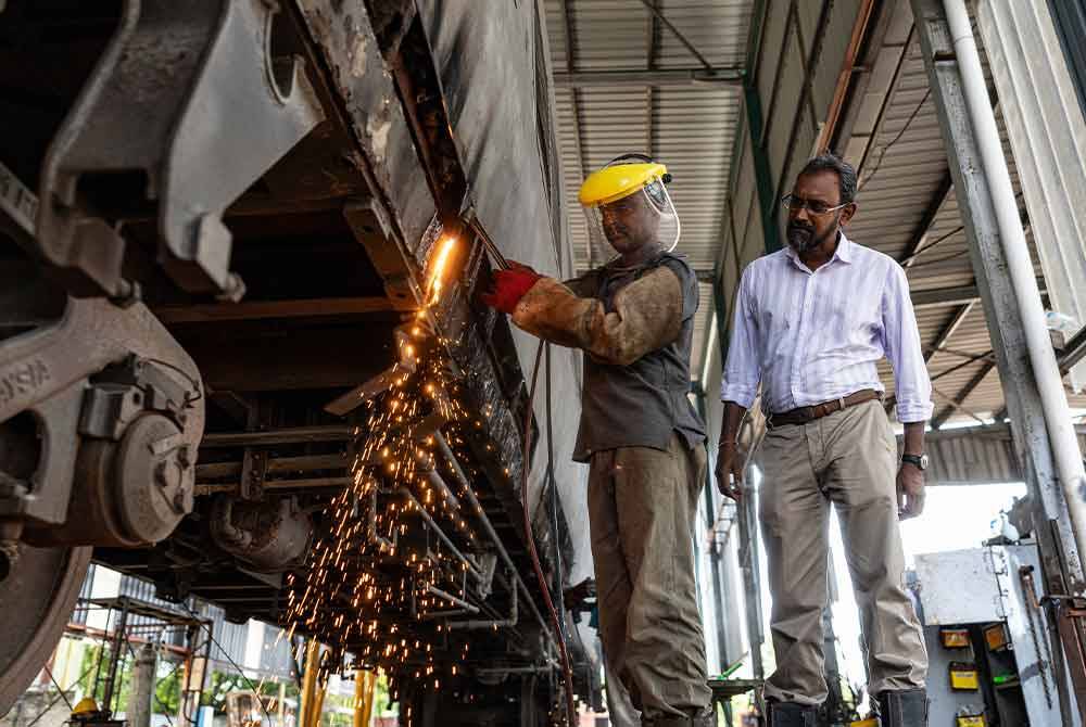 Ganesan (kanan) memantau kerja-kerja yang dilakukan oleh mekaniknya ketika ditemui Bernama di bengkelnya di Jalan Tun Abdul Razak baru-baru ini. Foto Bernama
