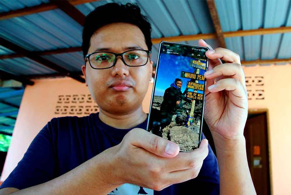 Zaid menunjukkan gambar abangnya pendaki Allahyarham Zulkifli Yusuf berada di puncak Uhuru Gunung Kilimanjaro, ketika ditemu bual oleh media di kediamannya di Kampung Tebuk Trong baru-baru ini. Foto Bernama