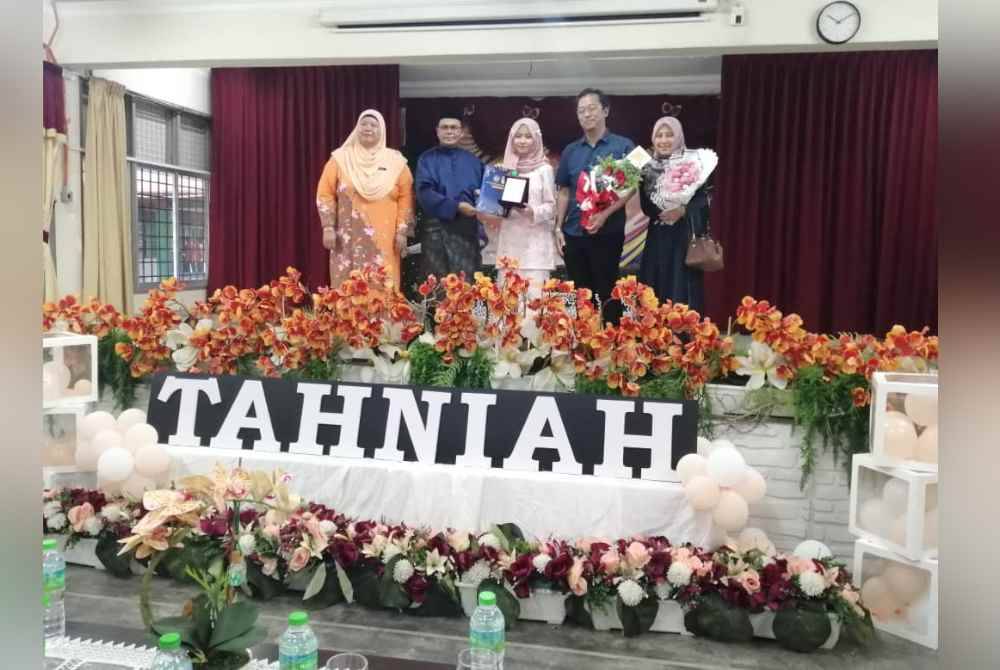 Mohd Fauzi (dua dari kiri) menyampaikan anugerah pelajar cemerlang SPM kepada Nur Aisyah Syafiqah.