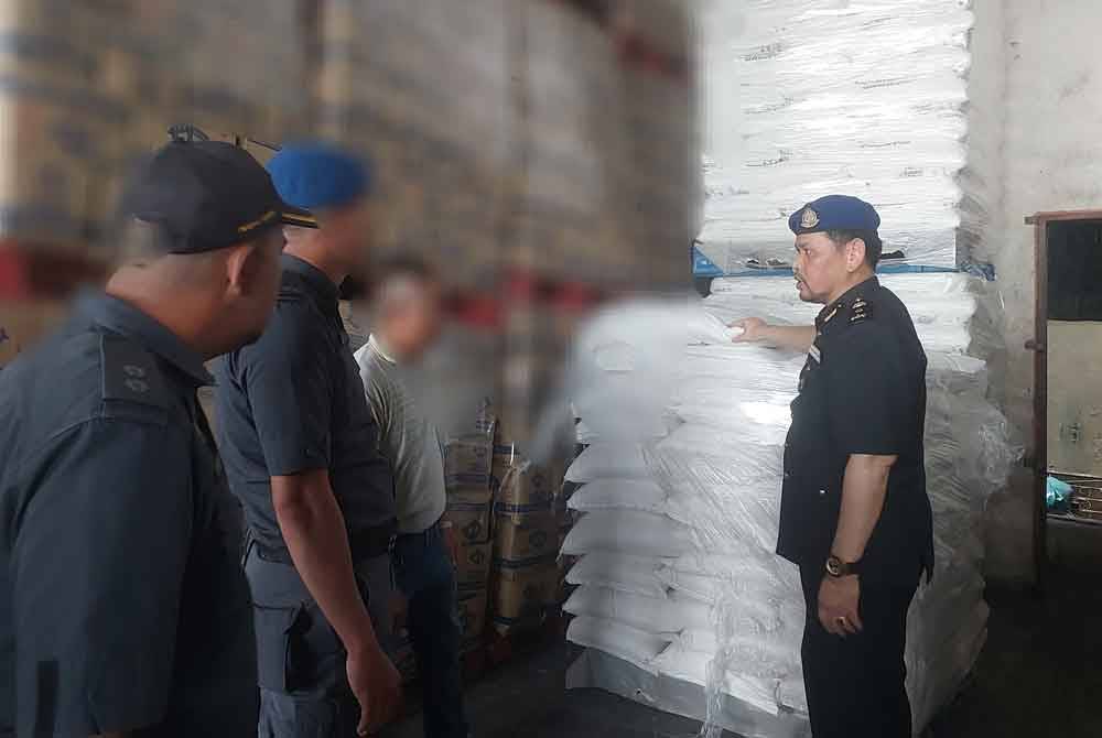 Saharuddin (kanan) ketika melakukan pemeriksaan di sebuah syarikat pemborong