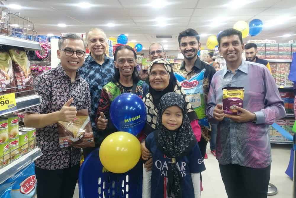 Fahmi (kiri) beramah mesra dengan pelanggan Mydin Mart Pantai Dalam pada Sabtu.