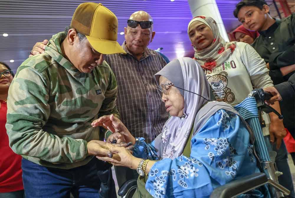 Peserta ekspedisi pendakian Gunung Denali, Alaska, Amerika Utara, Zainudin Lot menunjukkan kesan kecederaan pada jarinya disebabkan oleh pembekuan kulit dan tisu (frostbite) kepada ibunya, Jasidah Hamid, 73, sejurus tiba di Lapangan Terbang Antarabangsa Kuala Lumpur (KLIA) Terminal 1 hari ini. Foto Bernama