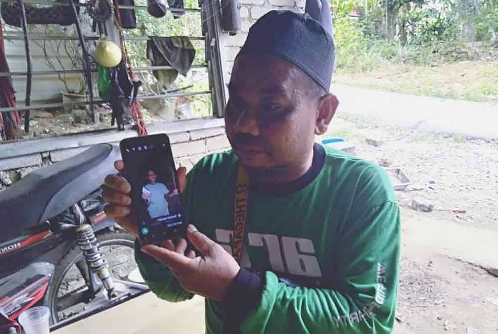 Mohd Delmi menunjukkan gambar kenangan anaknya yang terlibat kemalangan.