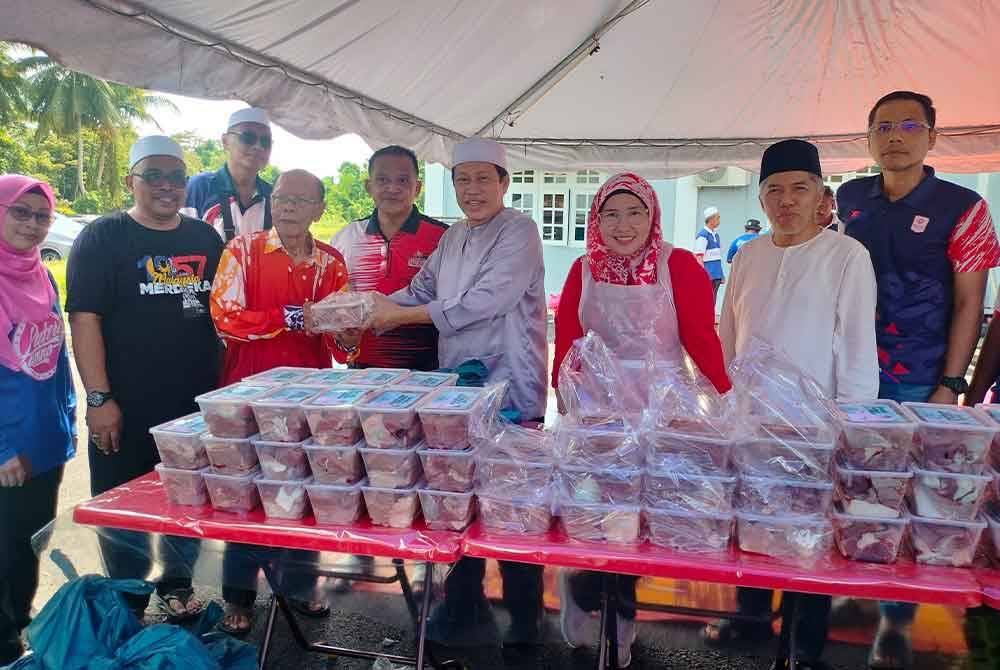 Ahmad Maslan (empat dari kanan) menyerahkan agihan daging korban kepada Abd Rahman di Pejabat UMNO Bahagian UMNO Pontian, pada Selasa.