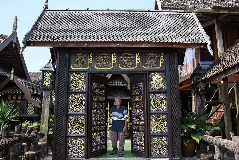Pemilik Resort Warisan Pahlawan, Tun Ahmad Tun Abdullah, 65, berada di salah satu pintu gerbang kayu diukir dengan kalimah Allah dan Muhammad serta ayat-ayat Al-Quran semasa ditemui di resort itu di Kampung Pauh, Jenagor, Hulu Terengganu.