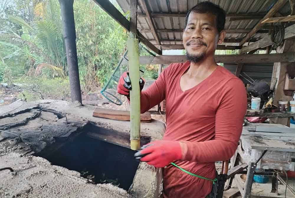 Mohd Zailani menunjukkan lemang yang siap dimasak dan sedia dijual kepada pelanggan.