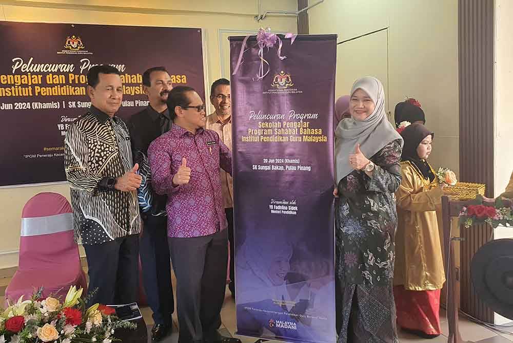 Fadhlina (kanan) ketika merasmikan Peluncuran Program Sekolah Pengajar dan Memartabatkan Bahasa Melayu dan Memperkukuh Bahasa Inggeris (MBMMBI): Sahabat Bahasa Institut Pendidikan Guru Malaysia di Sekolah Kebangsaan Sungai Bakap, pada Khamis.