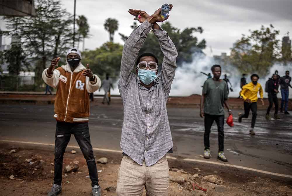 Seorang penunjuk perasaan membuat simbol 'pangkah' sambil melaungkan slogan antikerajaan semasa tunjuk perasaan menentang cadangan kenaikan cukai di Nairobi.