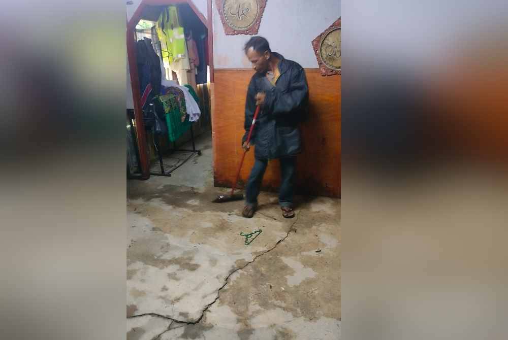 Abd Rashid mengemas rumah selepas air banjir mula surut.