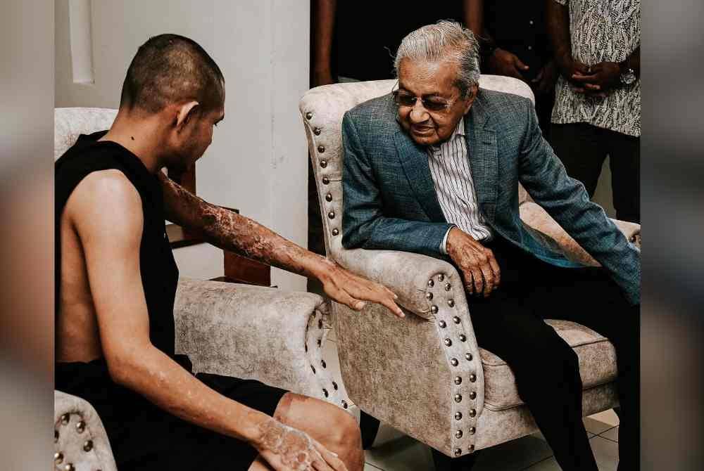 Tun Dr Mahathir ketika menziarahi Faisal Halim di kediamannya pada Sabtu.