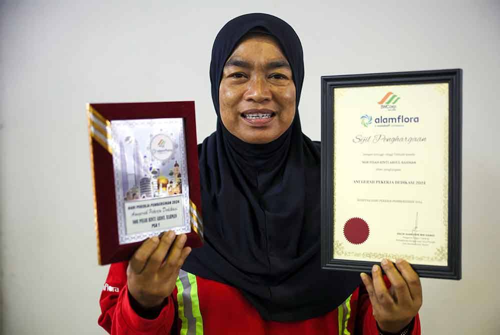Nor Pisah bergambar selepas menerima Anugerah Pekerja Dedikasi 2024 sempena Sambutan Hari Pekerja Pembersihan 2024. Foto Bernama