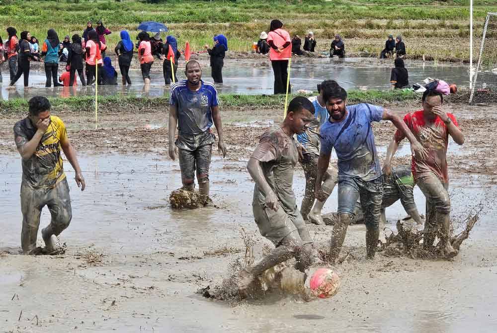 Pasukan pelajar antarabangsa merasai pengalaman berkubang dalam bendang ketika menyertai Karnival Sukan Bendang Daerah Perak Tengah di Bendang Layang-Layang Kanan, Parit pada Sabtu.