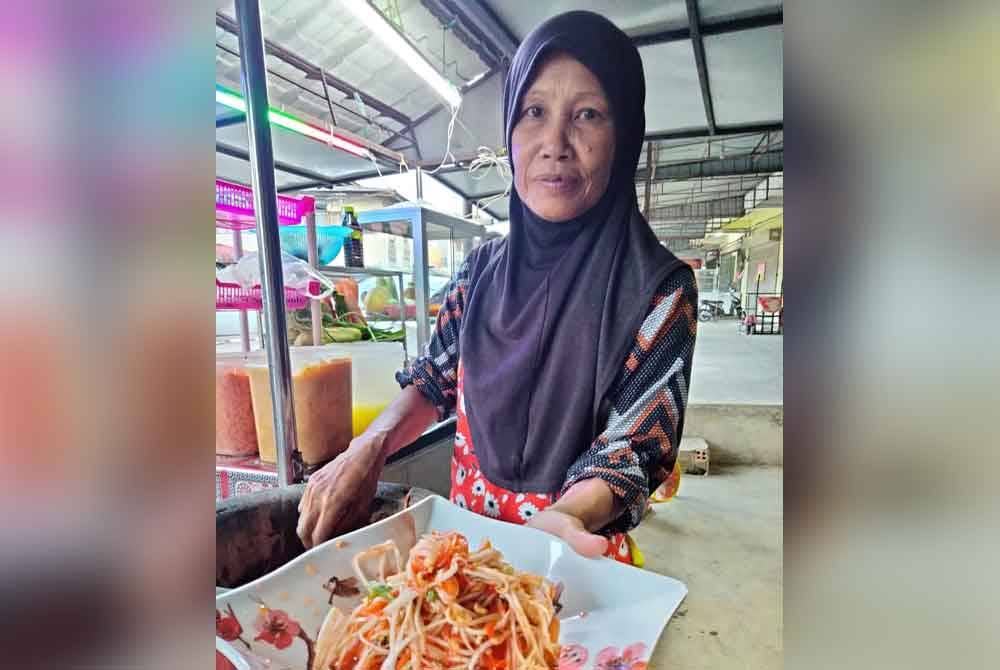 Siti Khadijah menunjukkan somtam campur yang dijual di gerainya.