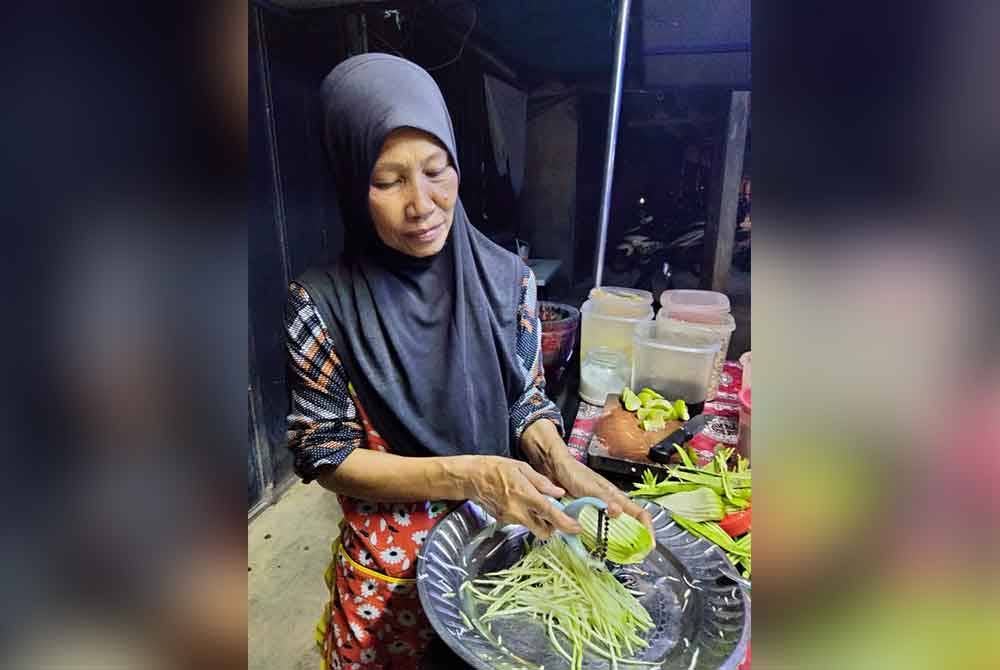 Siti Khadijah memotong mempelam untuk dijadikan somtam.