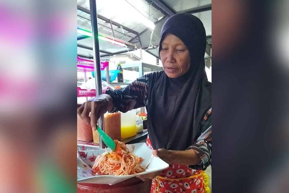 Siti Khadijah beri pelanggannya mencuba rasa somtam yang dibuat sebelum membungkusnya untuk dibawa pulang atau dihidangkan di gerainya.