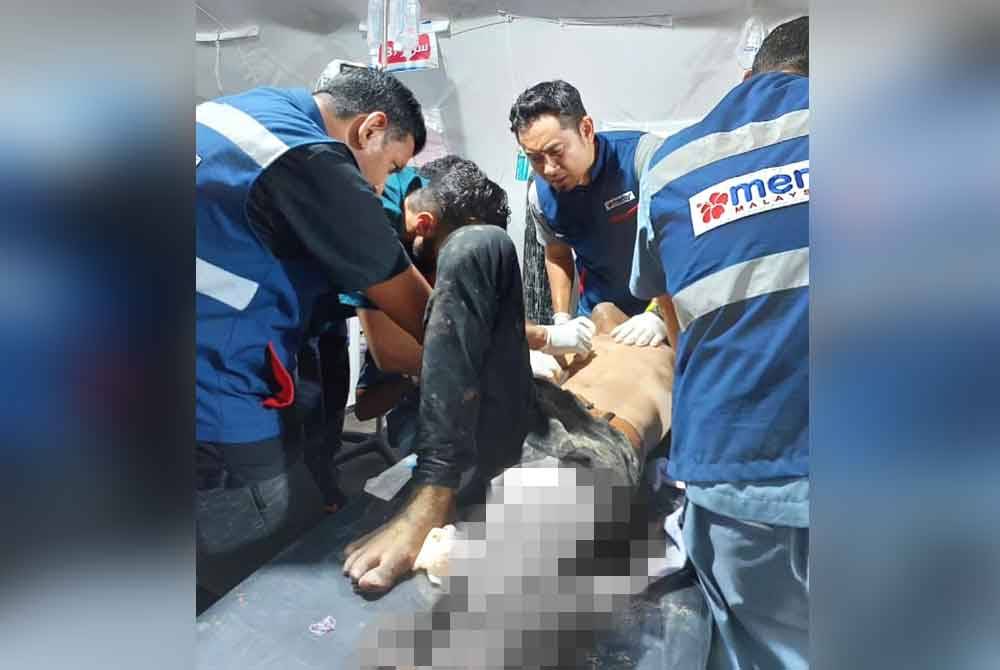 Dr Haniif (tengah) melihat kecederaan yang dialami mangsa perang yang dihantar ke Hospital Pakar Kuwait.