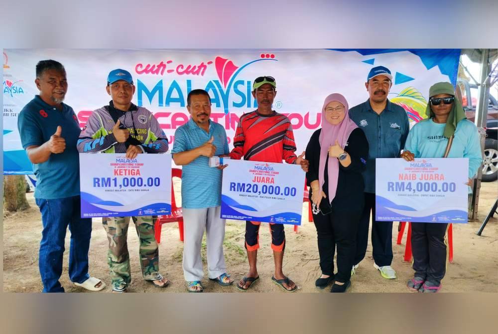 Md Zali (dua dari kanan), Shafik Fauzan (tiga dari kanan) dan Rugayah bergambar bersama tiga pemenang hadiah utama pertandingan memancing Cuti-Cuti Malaysia Surfcasting Tour-A Journey To VM2026 di Pantai Sepat di sini pada Ahad.