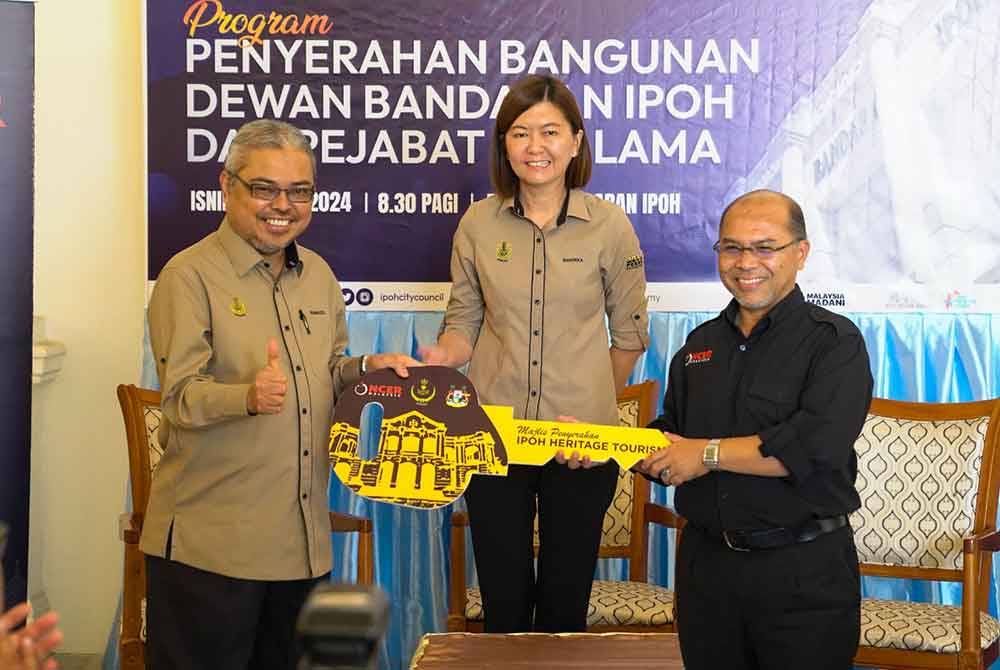 Sandrea menyaksikan penyerahan kunci bangunan Dewan Bandaran antara Fauzan (kanan) kepada Rumaizi di Dewan Bandaran Ipoh pada Isnin.