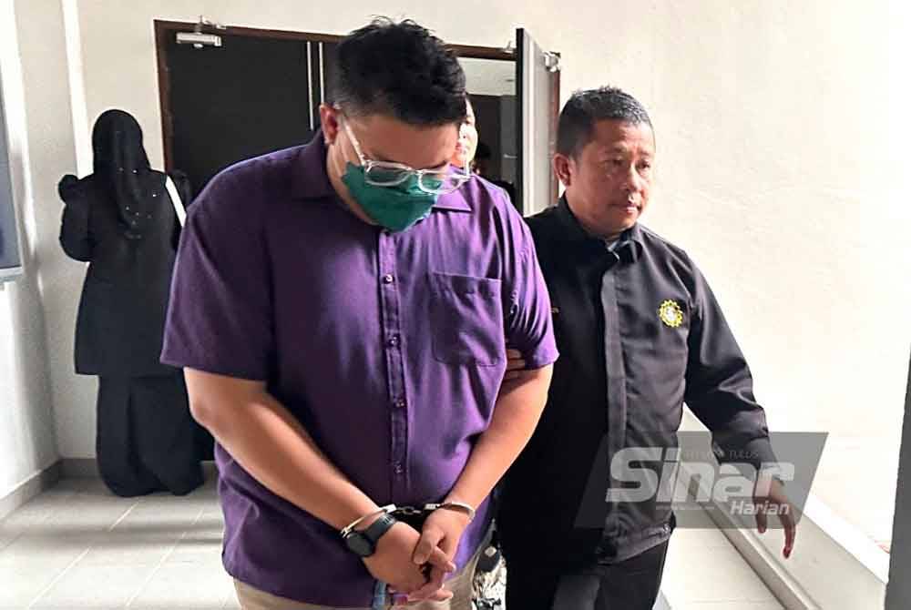 Muhammad Alif Heikal (kiri) dikawal anggota SPRM ketika dibawa ke Mahkamah Kota Bharu pada Isnin.