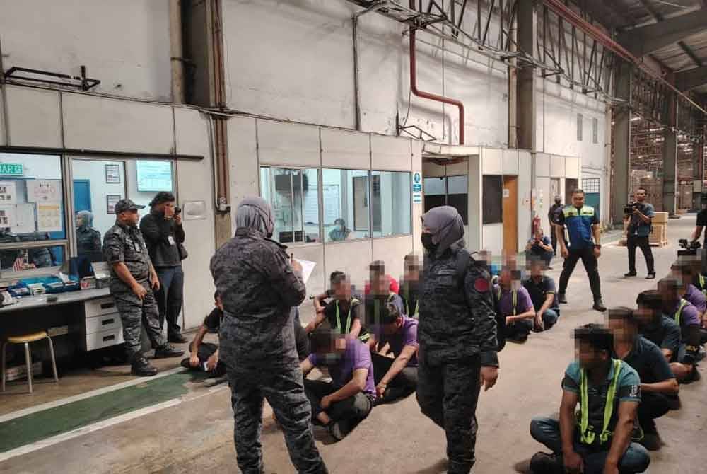 Antara warga asing yang ditahan dalam serbuan di sebuah kilang di sini, pada Isnin.