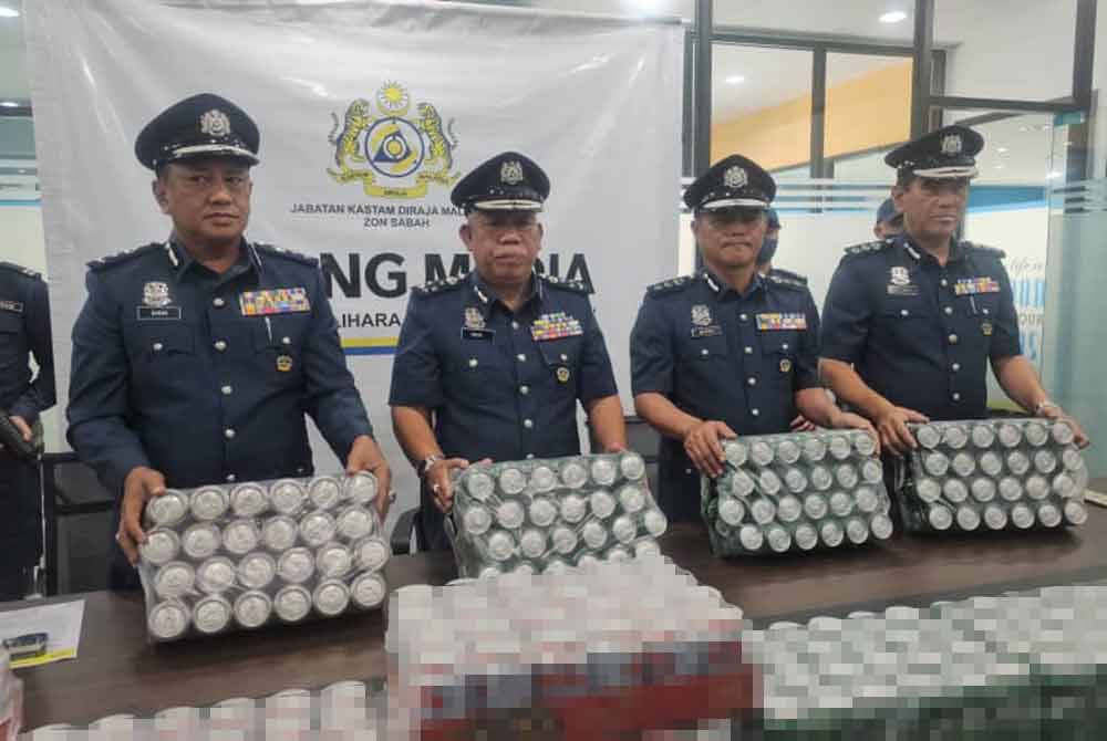 Mohd Nasir (dua dari kiri) menunjukkan minuman keras yang dirampas dalam serbuan di Jalan Lama Papar-Kota Kinabalu, Kampung Novoung, Papar.