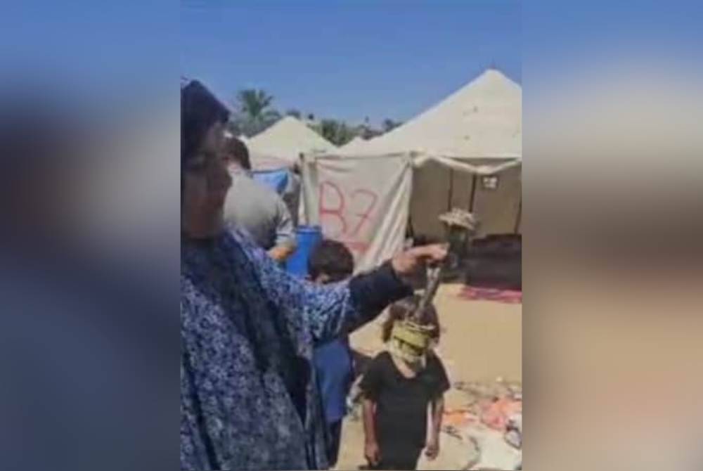 Seorang pelarian wanita menunjukkan antara bom yang dilontarkan tentera Israel semasa menyerang orang awam di kem perlindungan di An Nusairat, tengah Gaza, Palestin yang mengorbankan seorang wanita dan mencederakan lima penghuni