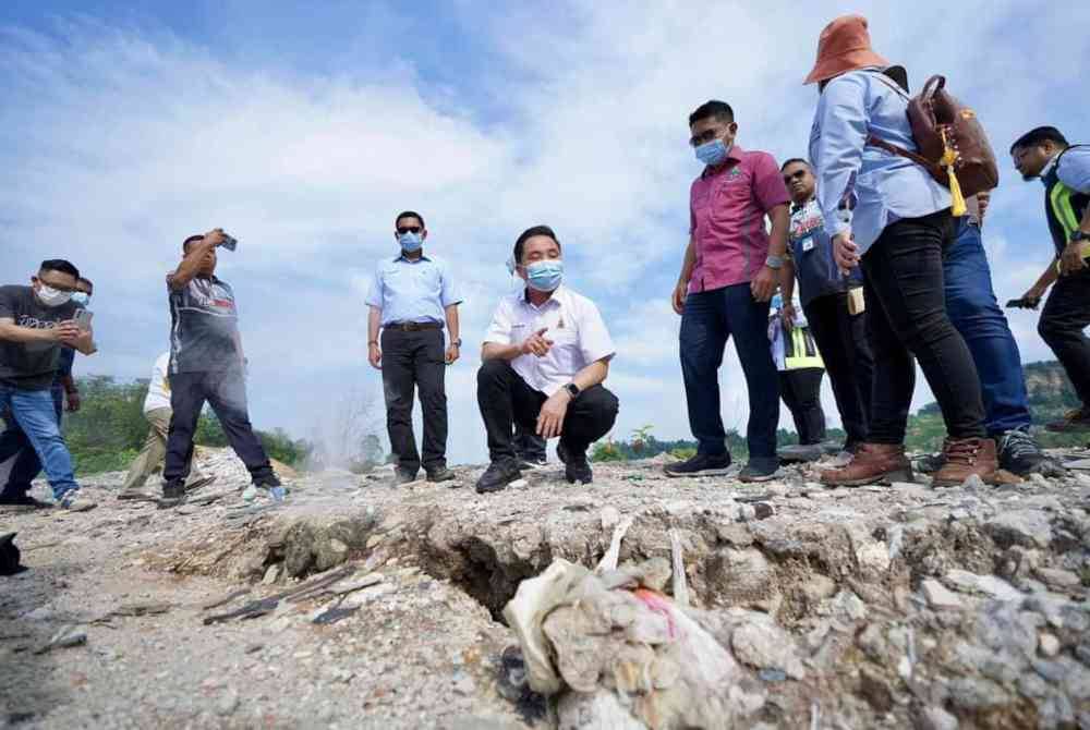 Suee Lim (empat dari kiri) melihat gas yang keluar dari tapak sampah haram di Black Water Lake, Bandar Mahkota Cheras pada Isnin.