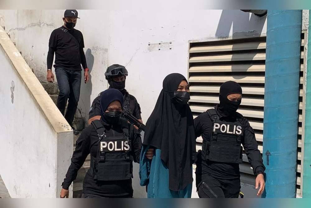 Suhaini (tengah) turut berhadapan dua lagi pertuduhan memberi sokongan kepada IS menggunakan dua akaun media sosial Facebook atas nama Suhaini Sarwan dan Enma Kenma.