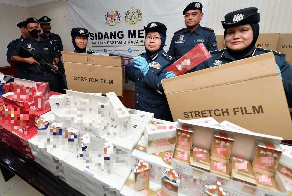 Norlela (tengah), bersama pegawai menunjukkan rokok yang dirampas semasa sidang media berkaitan kejayaan menyekat penyeludupan pokok bonsai, rokok, minuman keras, dan kipas angin dengan anggaran nilai dan cukai berjumlah RM2.04 juta di Pejabat Kastam Pelabuhan Utara pada Selasa. Foto Bernama