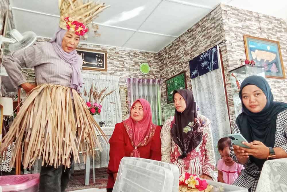 Mak Teh (kiri) ketika melihat aksesori bagi tarian sewang bersama Siti Norain (kanan),Siti Farhana (dua kanan) dan Afzainizam.
