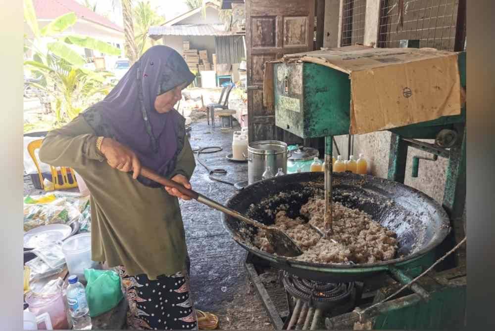 Suri menunjukkan kaedah penyediaan adunan kuih lok lik ketika ditemui pemberita di Dataran Batu Putih, Marang.
