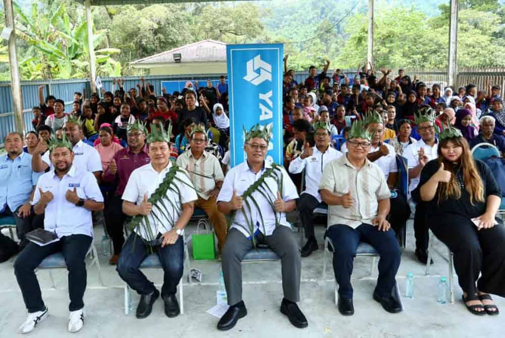Philip (tengah) bergambar bersama penerima ketika majlis penyerahan bantuan persekolah di SK Pos Raya, Simpang Pulai, Perak.