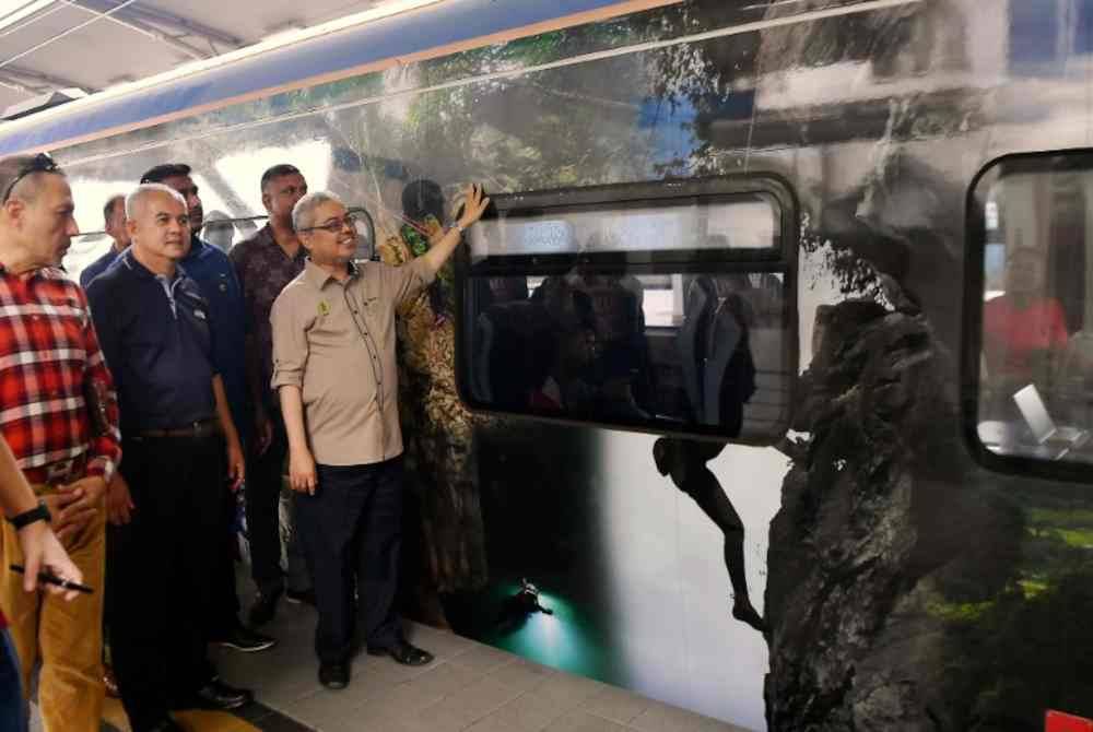 Datuk Bandar Ipoh, Datuk Rumaizi Baharin (kiri) melihat gerabak kereta api yang dilekatkan gambar tempat-tempat menarik di Ipoh selepas melancarkan Pengiklanan Pakej Promosi Maklumat Produk-Produk dan Tempat-Tempat Pelancongan Menarik di Bandar Raya Ipoh Melalui PerkhidmatanKereta Api Elektrik (ETS) di Stesen Kereta Api Ipoh hari ini.