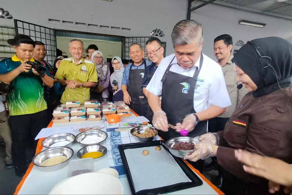 Mohamad (dua dari kanan) menunjukkan bakatnya membuat biskut pada Program Jom Masak Sihat Citarasa Peladang, di Tasek Cempedak, pada Rabu.