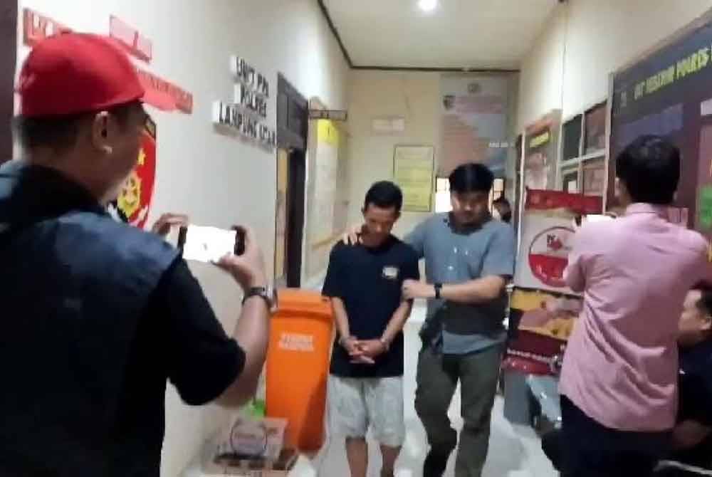 Sudadi dibawa oleh polis untuk dibicarakan. Foto Agensi